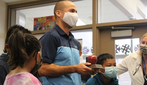  Mr. Perez stands with his students holding the bronze apple award for Teacher of the Year.